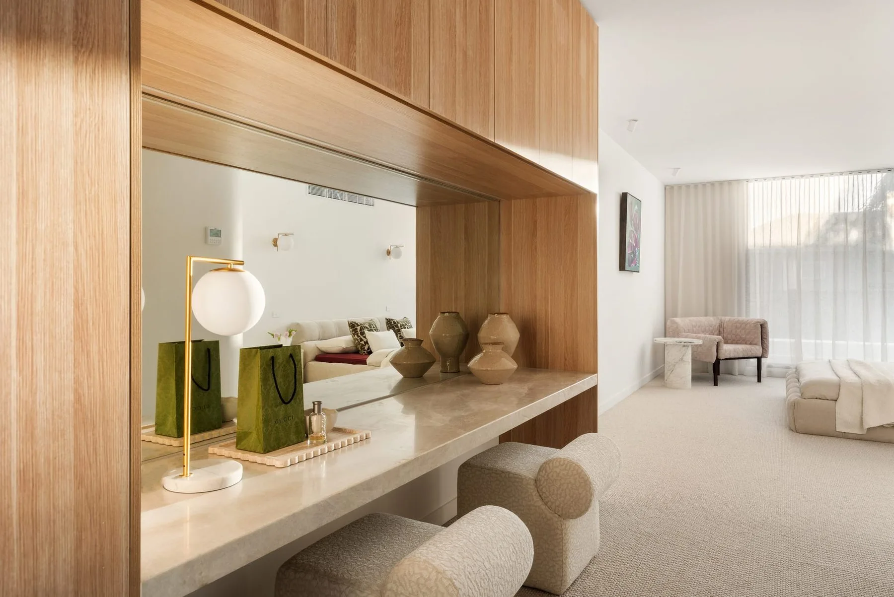 Dressing nook in a main bedroom with sheer curtains beyond