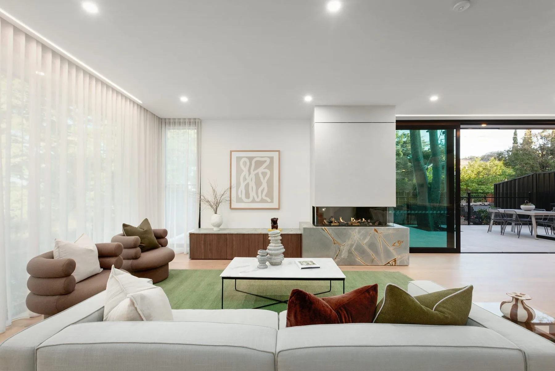 Living room with sheer curtains and a fireplace